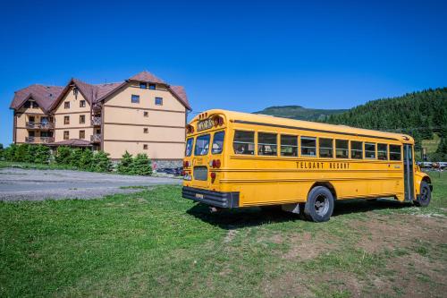 a yellow school bus parked in a field at Apartmány Ski Telgárt - Telgárt Resort in Telgárt