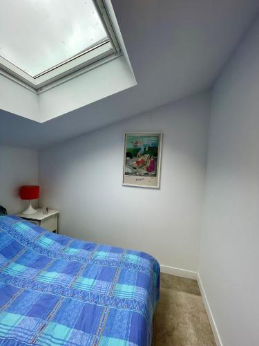 a bedroom with a blue bed and a window at Appartement 2 ch Anglet Biarritz in Anglet