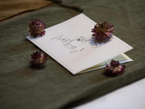 a book sitting on top of a table with flowers at Dan’s Sea Guest House Hangzhou in Hangzhou