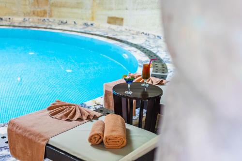 a table with a drink and towels next to a pool at Utopia Cave Cappadocia in Urgup