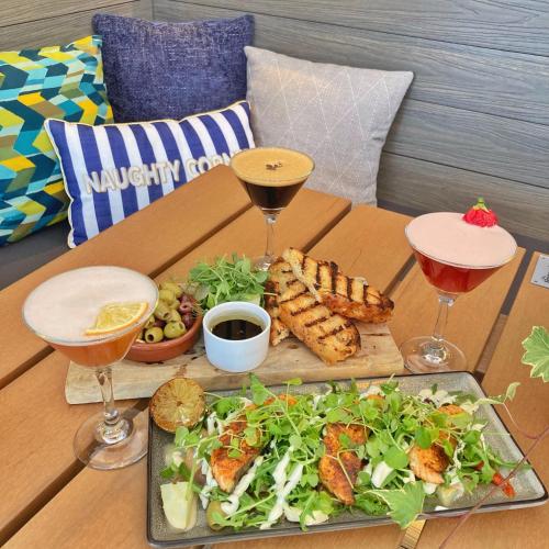 a table with a plate of food and two wine glasses at The Britannia Inn & Waves Restaurant in St Austell