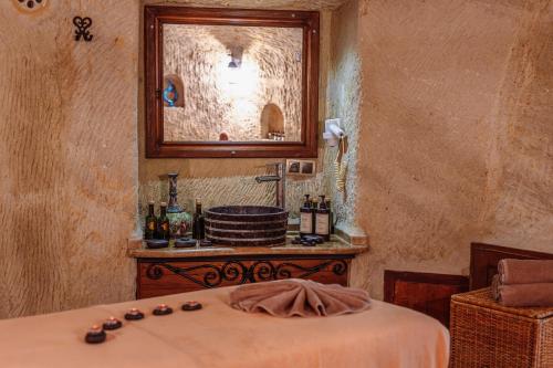 a room with a bed with a mirror and a sink at Utopia Cave Cappadocia in Urgup