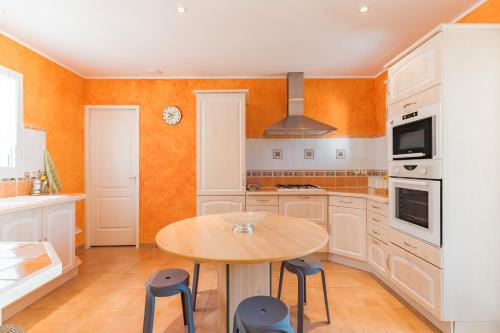 a kitchen with a wooden table and chairs in it at Le Verger du Midi in Cadenet