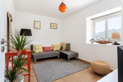 a living room with a couch and a window at GuestReady - Quaint house with Patio in Sintra