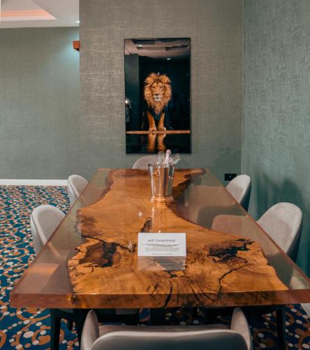 a table with a picture of a lion on the wall at Swiss International Rancho Valeria, Warri in Warri
