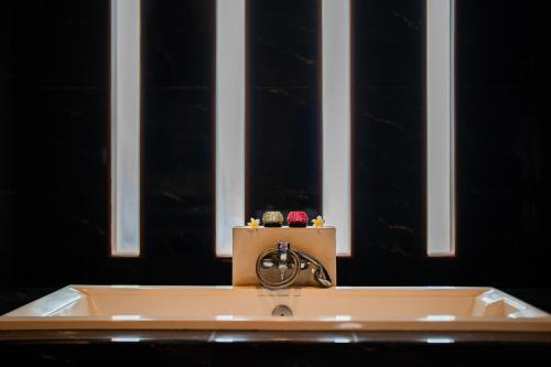 a bath tub with a faucet in front of a window at The Casa Amaya in Jimbaran