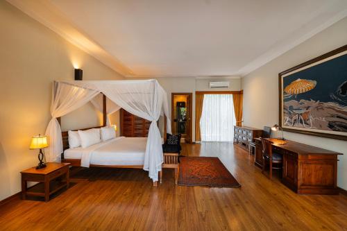 a bedroom with a bed with a canopy at The Casa Amaya in Jimbaran