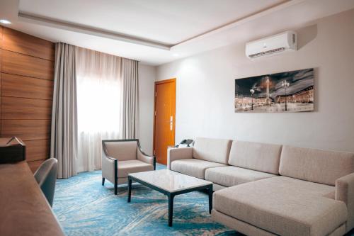 a living room with a couch and a table at Swiss International Rancho Valeria, Warri in Warri