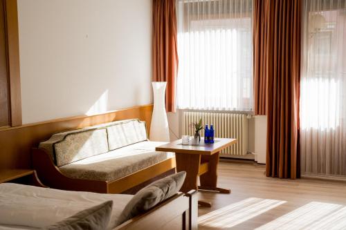 a hotel room with a bed and a table at Vinami-Sonne Hotel in Bad Wildbad