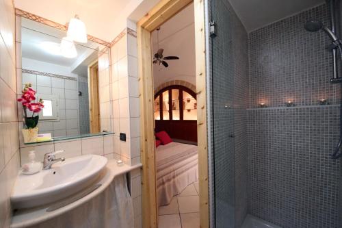 uma casa de banho com um lavatório e um chuveiro com um espelho. em B&B Don Gino em Monopoli