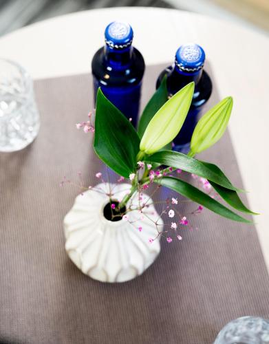 two blue bottles and a white vase with a plant at Vinami-Sonne Hotel in Bad Wildbad