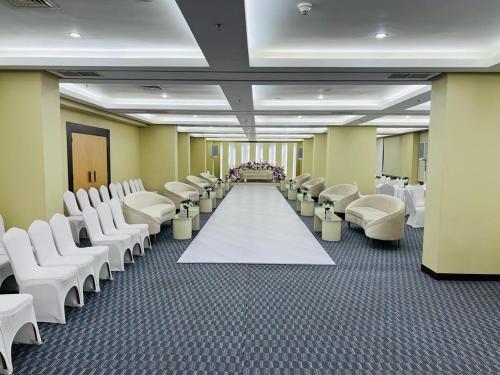 a room with rows of white chairs and a white aisle at Best Western Plus Mahboula in Kuwait