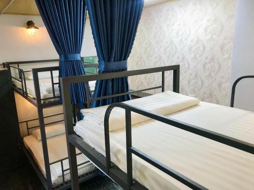 two bunk beds in a room with blue curtains at Cozy 86 Homestay in Can Tho