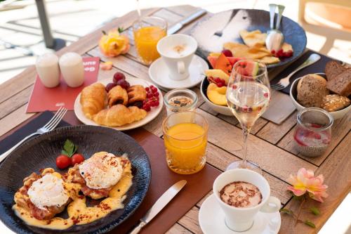 a table topped with plates of food and glasses of wine at Hotel Laguna - Terme Krka in Strunjan