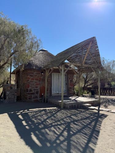 a brick building with a pavilion in front of it at Tsauchab River Camp in Sesriem