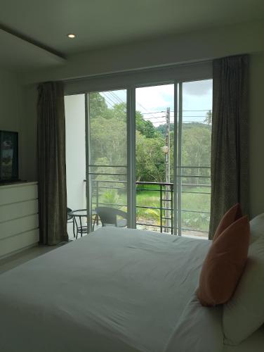 a bedroom with a bed and a large window at Baan Didi2 in Bophut 