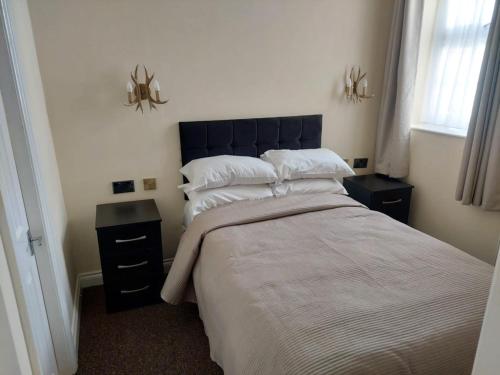 a bedroom with a large bed and two night stands at Edenfield Lodge in Blackpool