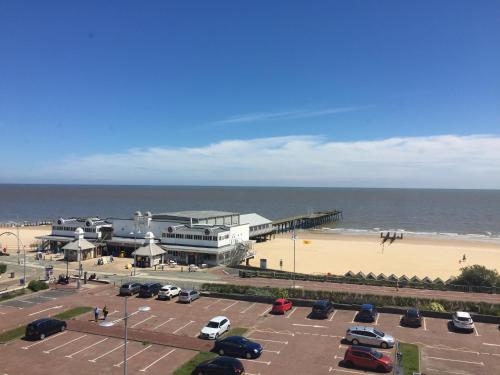 a parking lot next to a beach with a pier at The Clyffe Hotel in Lowestoft