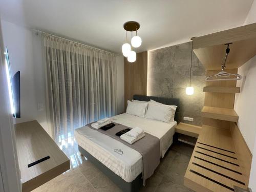 a small bedroom with a bed with white sheets at Trinity Pool Villas WHITE in Iraklitsa