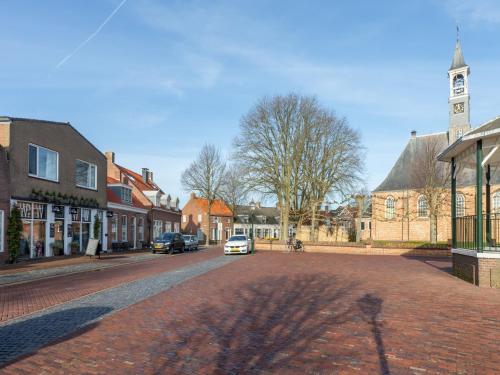 a street in a small town with a clock tower at Lovely, modern, 4-person apartment in the heart of Koudekerke in Koudekerke