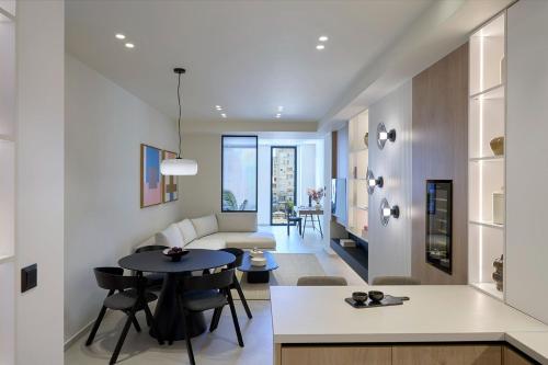 a living room with a table and a couch at Fasma Suites Luxury Apartments in Piraeus in Piraeus