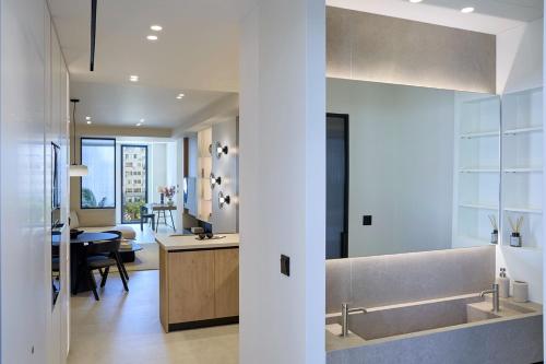 a kitchen with a sink and a dining room at Fasma Suites Luxury Apartments in Piraeus in Piraeus