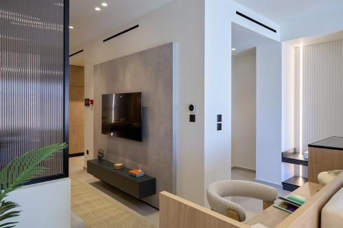 a living room with a tv on a wall at Fasma Suites Luxury Apartments in Piraeus in Piraeus