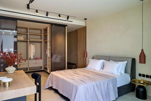 a bedroom with a bed and a table and a room at Fasma Suites Luxury Apartments in Piraeus in Piraeus
