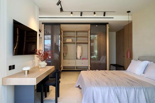 a bedroom with a bed and a table and a desk at Fasma Suites Luxury Apartments in Piraeus in Piraeus
