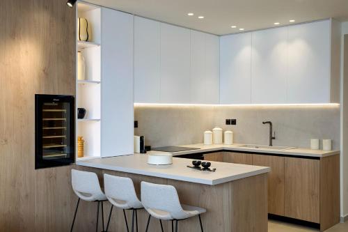 a kitchen with a island with four chairs around it at Fasma Suites Luxury Apartments in Piraeus in Piraeus