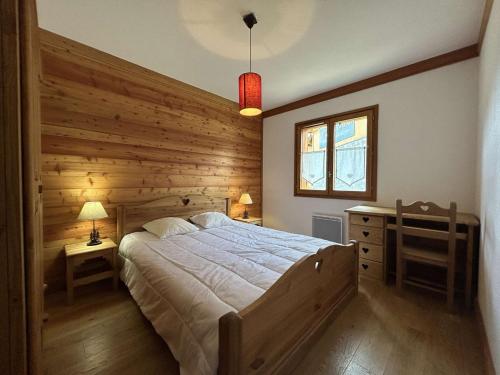 - une chambre avec un grand lit et un mur en bois dans l'établissement Appartement Ski aux Pieds, 6 Pers, Montgenèvre – Terrasse et Confort - FR-1-330D-67, à Montgenèvre