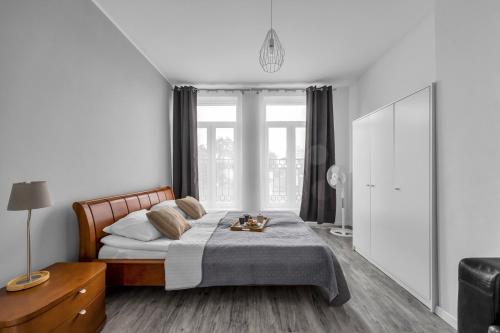 Un dormitorio con una cama y una ventana grande. en Praga Apt - 45m2, French Balcony - by Rentujemy, en Varsovia