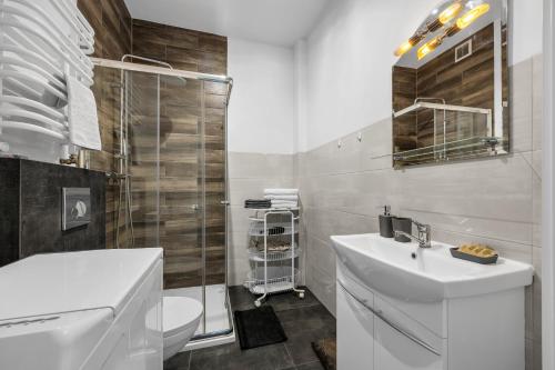 Un baño blanco con lavabo e inodoro. en Praga Apt - 45m2, French Balcony - by Rentujemy, en Varsovia