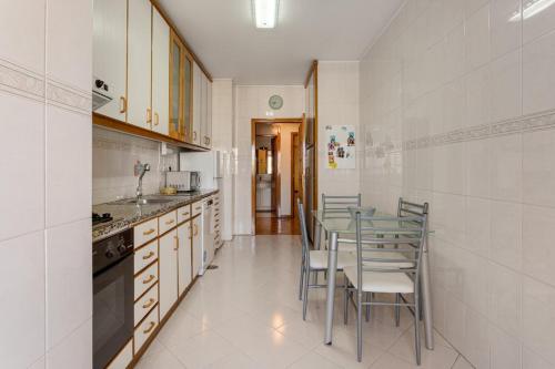 a kitchen with a table and chairs in it at GuestReady - Stylish City Centre Flat with Parking in Maia