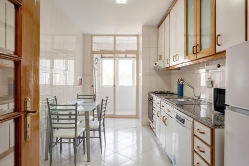 a kitchen with a table and chairs and a dining room at GuestReady - Stylish City Centre Flat with Parking in Maia