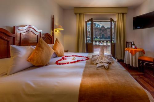 a bedroom with a large bed with red flowers on it at El Virrey Boutique in Cusco