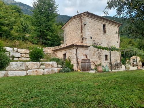 an external view of a stone building in a yard at Dimora del Capriolo in San Donato Val di Comino