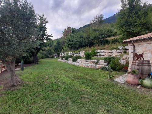 a garden with a stone wall and a yard at Dimora del Capriolo in San Donato Val di Comino
