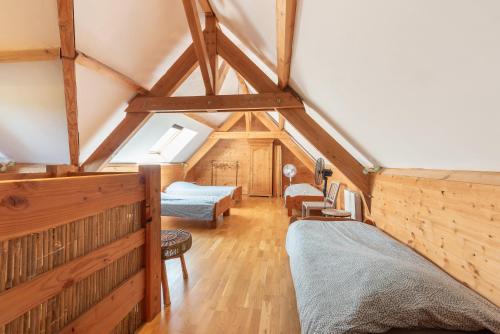 a attic room with two beds and a room with beams at La Buena Onda in Herrère
