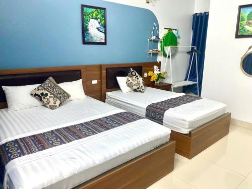two beds in a room with blue walls at Blue Garden Homestay in Ninh Binh