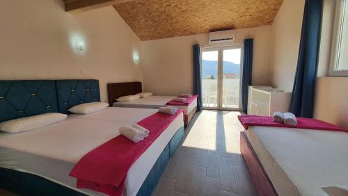two beds in a room with a large window at Villa Golf 2 in Budva