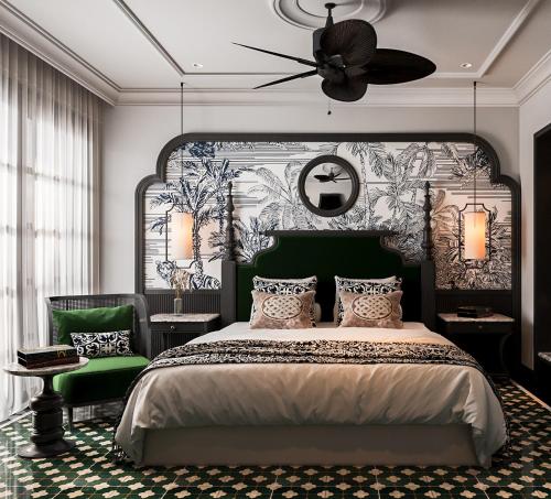a bedroom with a large bed and a ceiling fan at L'Heritage Riverside Hoi An in Hoi An