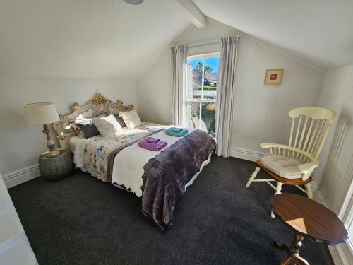 a bedroom with a bed and a chair and a window at Welcome to Blue Morning house! - Remuera 5 bedrooms villa in Auckland
