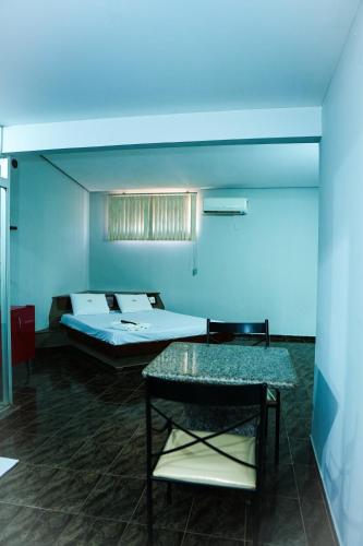a room with two beds and a table in it at Rodotel Vênus Prime in Rio Verde