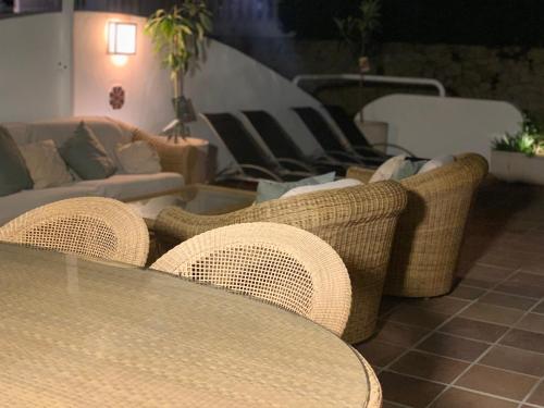 a room with a table and wicker chairs and a couch at Beachfront Villa in Moraira