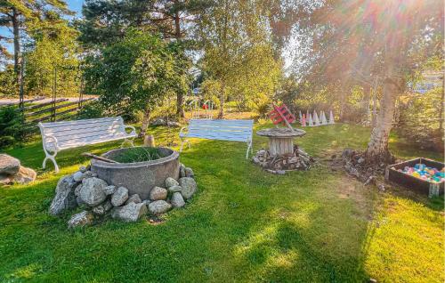 a park with a bench and a fountain in the grass at 3 Bedroom Stunning Home In Strömstad in Strömstad