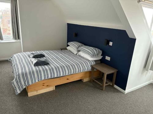 a bedroom with a bed with a blue wall at Adventure Apartment in Whitby