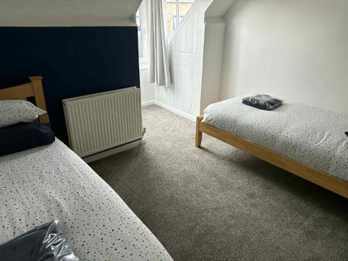 a bedroom with two beds and a window at Adventure Apartment in Whitby