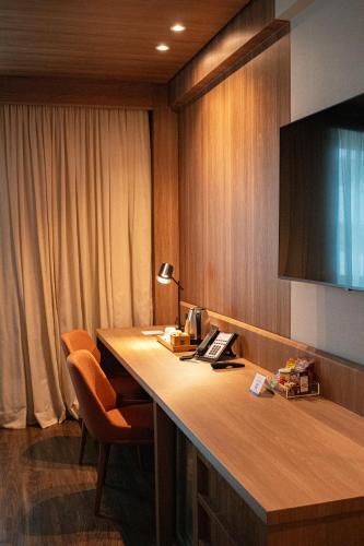 a hotel room with a desk and a television at Novotel Sao Paulo Center Norte in Sao Paulo
