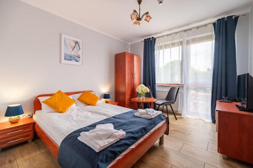 a bedroom with a bed and a desk and a television at Villa Morska, 350 m do plaży in Ustronie Morskie